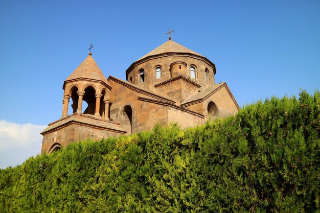 Chiesa di Saint Hripsime con gli arbusti sempreverdi in primo piano, città di Vagharshapat, Armenia