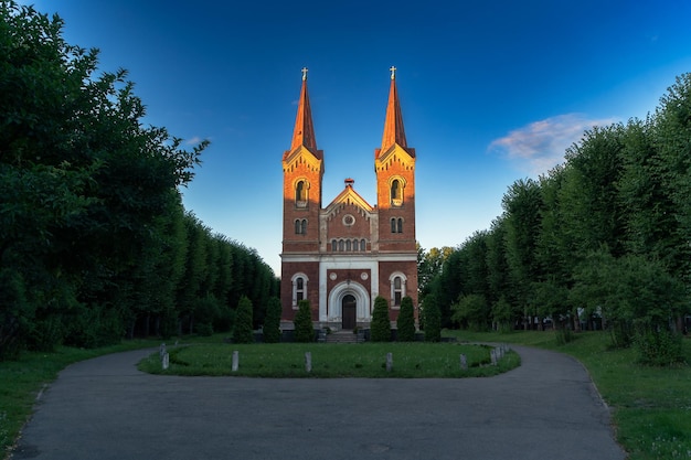 Chiesa medievale in mattoni rossi con due torri alla luce del tramonto