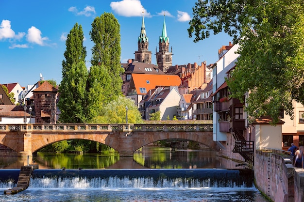 Chiesa soleggiata e ponte sul fiume Pegnitz nella città vecchia di Norimberga, Baviera orientale, Germania