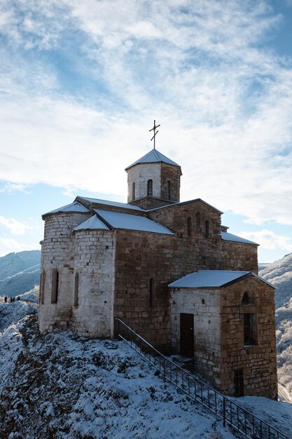 Chiesa sulla roccia nella neve monastero sulla montagna cappella pagoda paesaggio invernale neve sul tetto e le pendici delle montagne chiesa sulla roccia