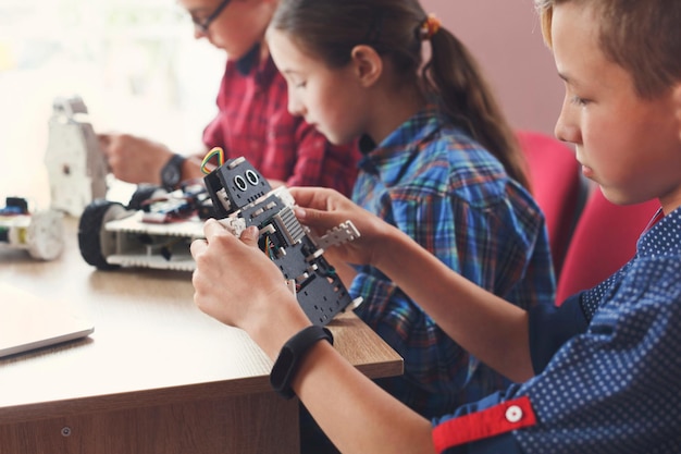 Children creating robots at school, stem education, copy space. Early development, diy, innovation, modern technology concept