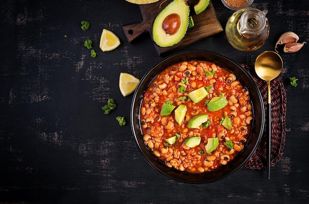 Chili con carne in una ciotola su sfondo scuro. Cucina messicana. Vista dall'alto, sopra