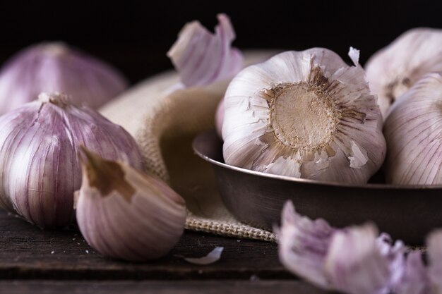 Chiodi di garofano di aglio e lampadina dell'aglio su tela da imballaggio dell'annata. Lampadine dell'aglio con i chiodi di garofano sulla parete della tela da imballaggio., Stile di vita sano di concetto