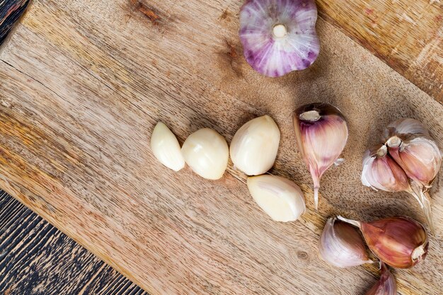 Chiodi di garofano e teste d'aglio maturo sul tavolo della cucina durante la cottura di un piatto con aglio