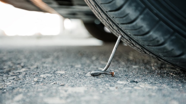 Chiodi su una strada asfaltata con un'auto