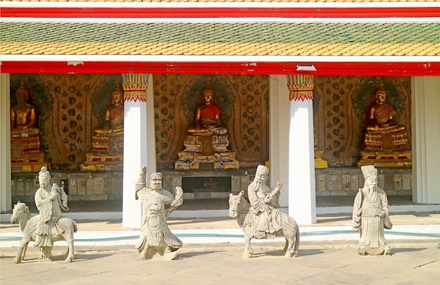 Chiostro del tempio di Wat Arun con immagini di Buddha e sculture di guardiani cinesi a Bangkok in Thailandia