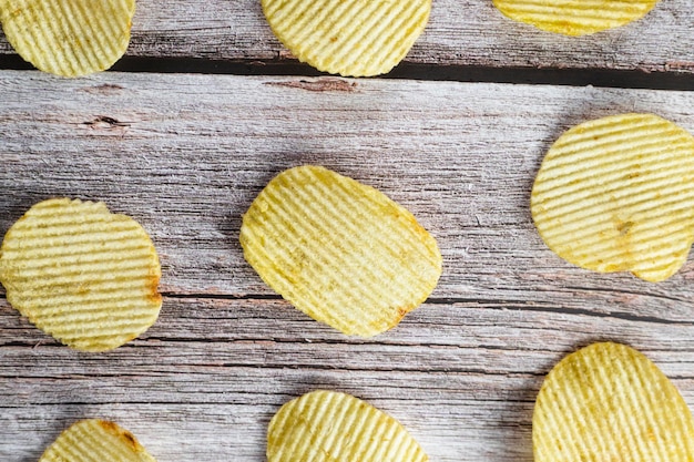 Chip di patate croccanti sullo sfondo di tavolo in legno Chip di patata fatti in casa serviti con senape rosmarino fleur de sel sale su sfondo di legno Copia spazio