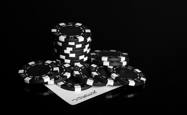 Chip e carta jolly sul tavolo nero del casinò Fortuna o successo nel gioco del poker