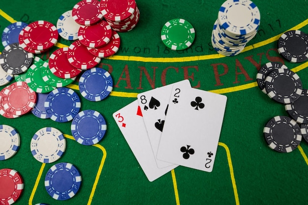 Chip e carte per giocare a poker giacciono sul concetto di gioco del casinò da tavolo