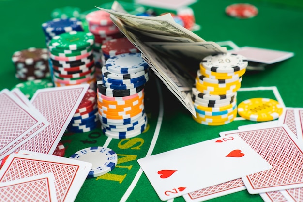 Chip e carte per il poker in mano sul tavolo verde