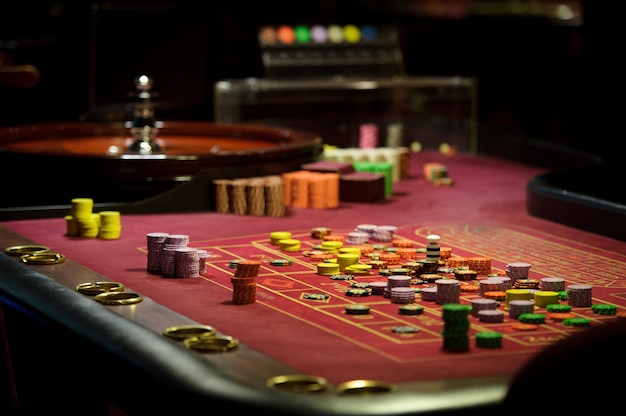 Chip e roulette del primo piano al casinò sul tavolo rosso