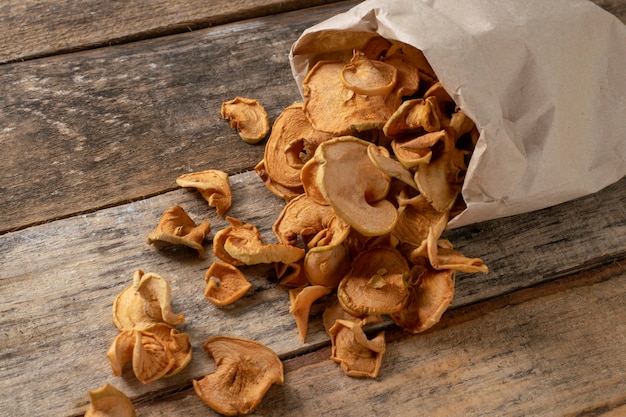 Chips di mele di frutta su uno sfondo di legno. Fette di mela essiccate.