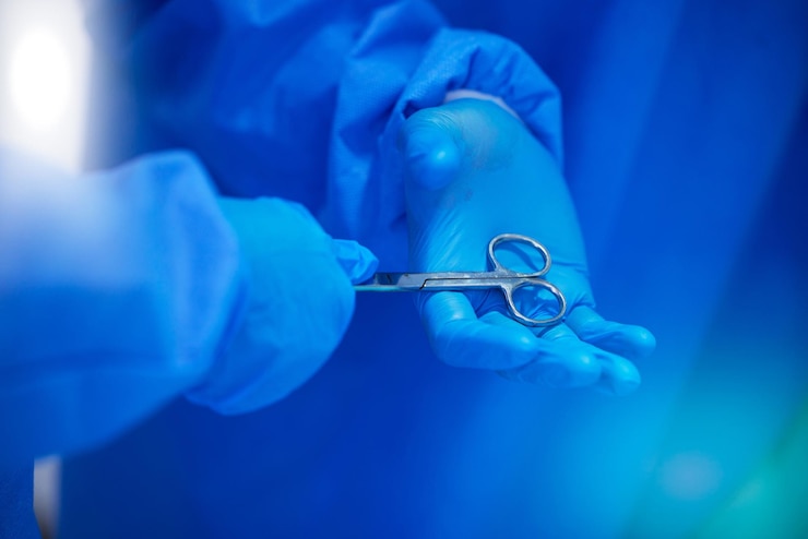 Foto chirurgia di primo piano e mani con una forbice per il lavoro ospedaliero sanitario e aiuto supportare il team e i medici chirurghi o dipendenti medici con guanti per cardiologia o cooperazione professionale