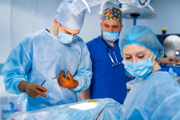 Chirurgia spinale Gruppo di chirurghi in sala operatoria con apparecchiature chirurgiche Background medico moderno