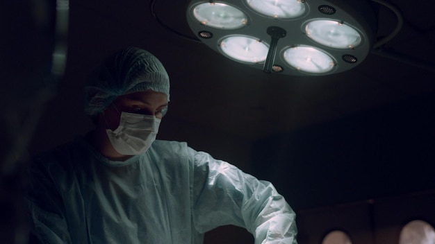 Chirurgo donna che esegue un'operazione nel reparto ospedaliero Cooperazione degli operatori sanitari