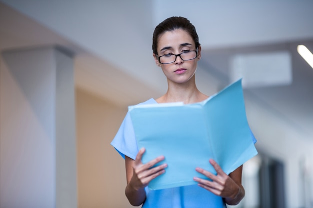 Chirurgo femminile che legge referto medico