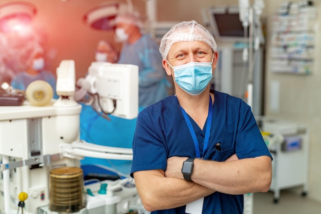 Chirurgo maschio che guarda l'obbiettivo in ospedale. Medico chirurgo professionista in maschera.