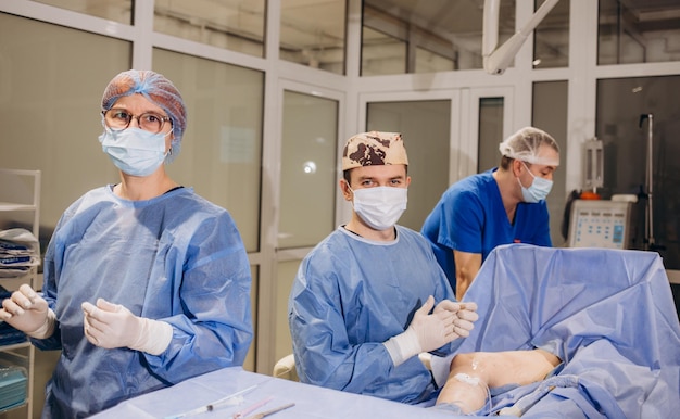 Chirurgo maschio che indossa un cappuccio protettivo e una maschera in piedi e prepara l'operazione Medico durante l'operazione Concetto di medicina