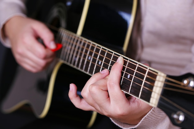 Chitarra acustica in primo piano mani femminili