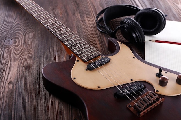 Chitarra elettrica con cuffie e notebook su un tavolo di legno