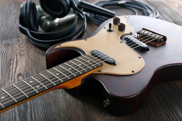 Chitarra elettrica con microfoni e cuffie sul tavolo di legno da vicino