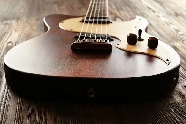 Chitarra elettrica sulla tavola di legno da vicino