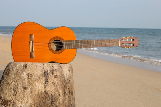 Chitarra sulla spiaggia di sabbia Nella bella estate