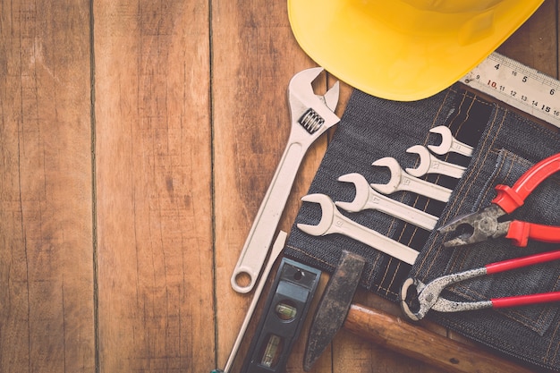 Chiuda in su degli strumenti di lavoro assortiti su fondo di legno