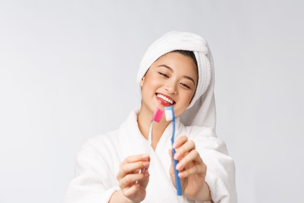 Chiuda in su dei denti della spazzola della donna di sorriso. ottimo per il concetto di cure odontoiatriche di salute, isolato sopra il muro bianco. asiatico.