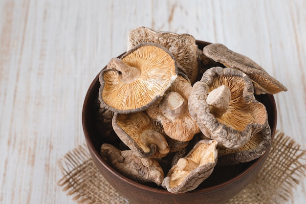 Chiuda in su dei funghi di shiitake secchi su di legno