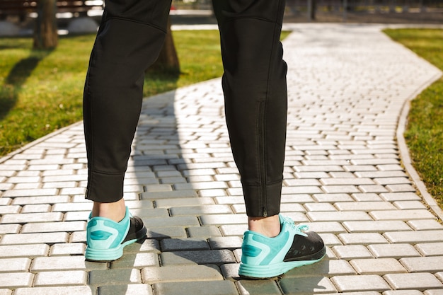 Chiuda in su dei piedini maschii in abbigliamento sportivo e scarpe da ginnastica