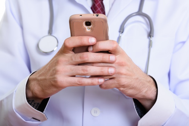 Chiuda in su del medico dell'uomo utilizzando il telefono cellulare