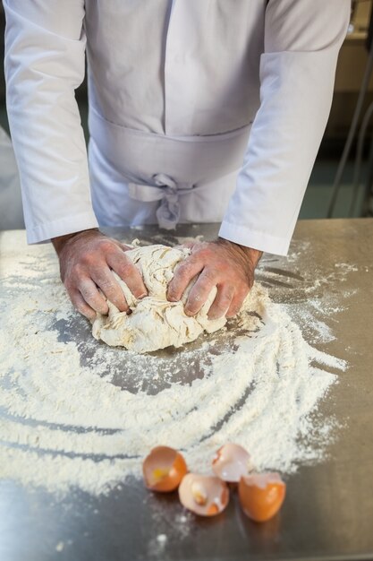 Chiuda in su del panettiere impastare la pasta