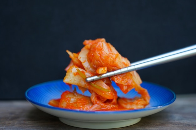 Chiuda in su dell'alimento di kimchi coreano organico con le bacchette