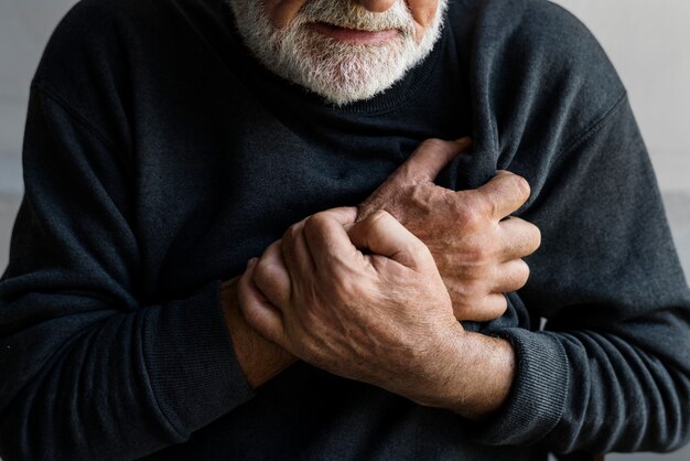 Chiuda in su dell&#39;uomo anziano che ha un attacco di cuore