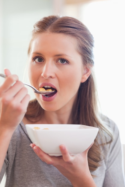 Chiuda in su della donna che mangia i cereali