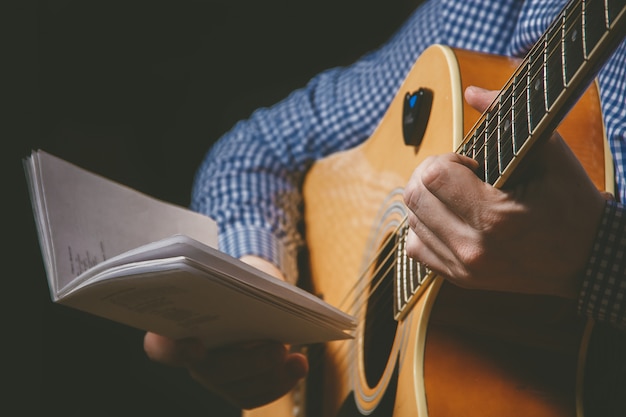 Chiuda in su della mano del chitarrista che gioca la chitarra