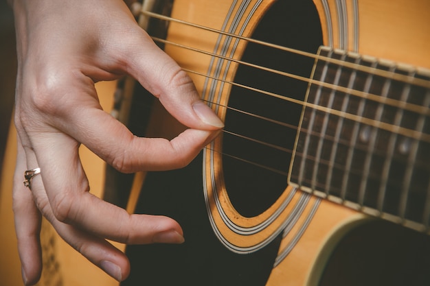 Chiuda in su della mano del chitarrista che gioca la chitarra