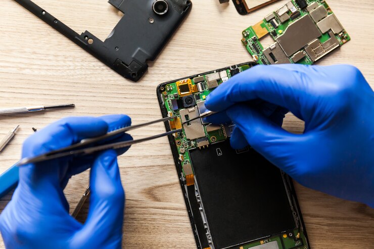 Chiuda in su della mano dell'uomo che ripara il telefono cellulare
