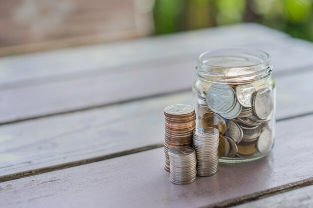 Chiuda in su della pila di monete in un vaso di vetro, affari, finanza, risparmio o denaro di gestione
