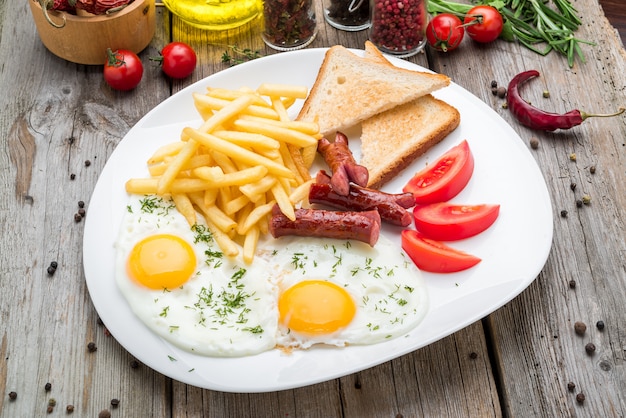 Chiuda in su della prima colazione continentale con l'uovo e la salsiccia