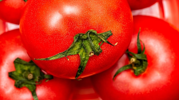 Chiuda in su della priorità bassa dei pomodori del pomodoro rosso maturo