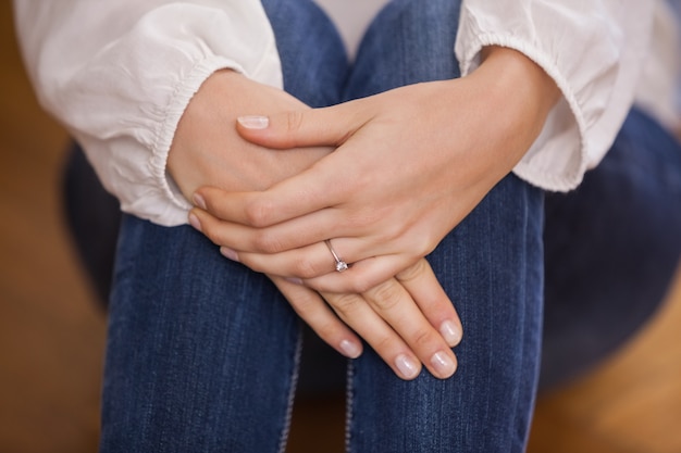 Chiuda in su della ragazza che si siede sul pavimento