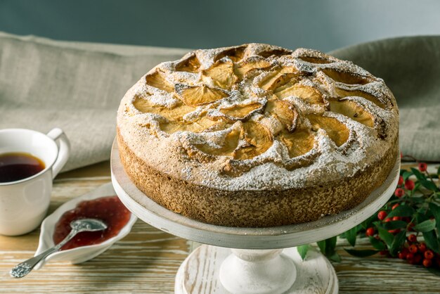 Chiuda in su della torta di mele con una crosta dorata sul tavolo