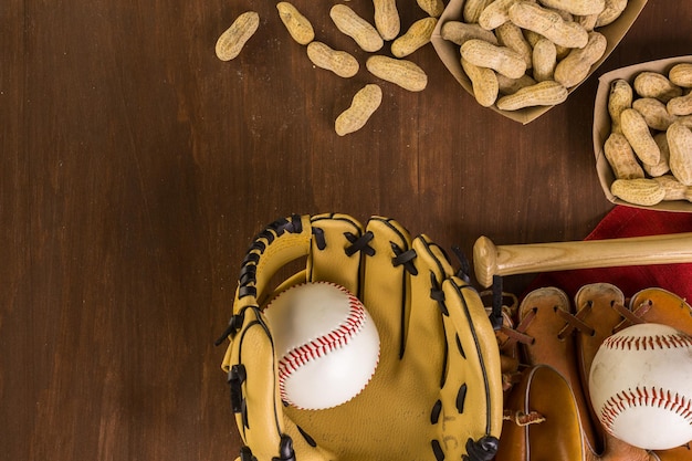 Chiuda in su della vecchia attrezzatura da baseball usurata su uno sfondo di legno.