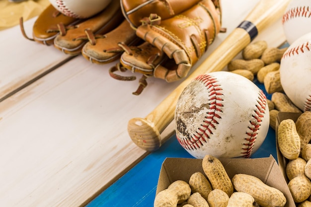 Chiuda in su della vecchia attrezzatura da baseball usurata su uno sfondo di legno.