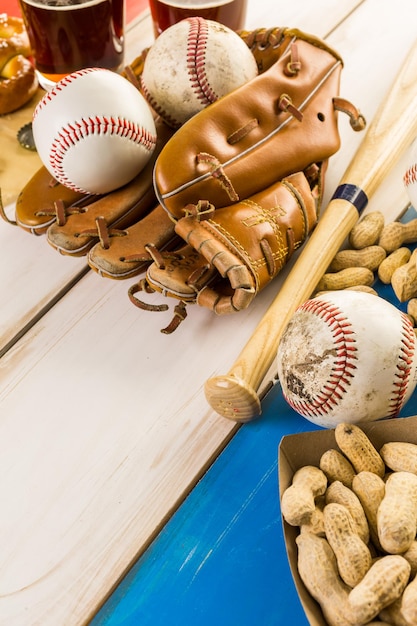 Chiuda in su della vecchia attrezzatura da baseball usurata su uno sfondo di legno.