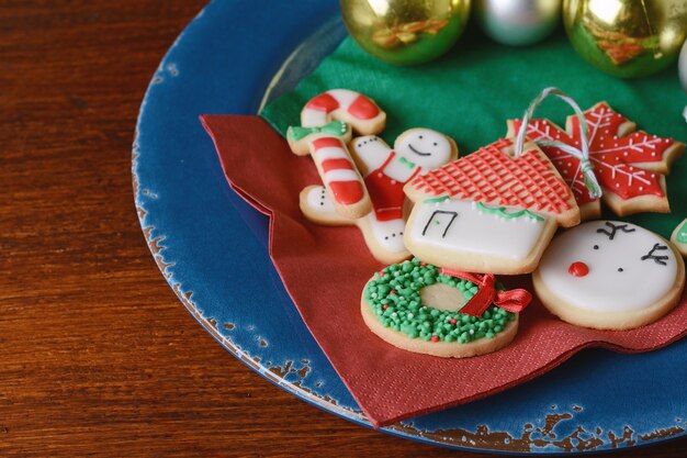 Chiuda in su della zolla con i biscotti variopinti di natale