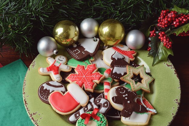 Chiuda in su della zolla con i biscotti variopinti di natale