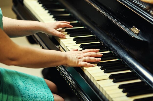 Chiuda in su delle mani di donna suonare il pianoforte